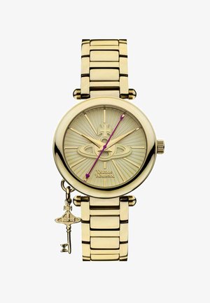 Gold metal watch with a round case, textured light-colored dial, purple hands, and a dangling charm. Features a linked bracelet design.