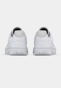 Par hvite joggesko vist bakfra på en ensfarget lys grå bakgrunn.