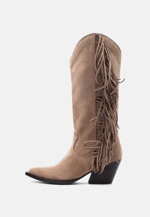 Tan suede cowboy boot with stacked heel and decorative long fringe along the outer side shaft.