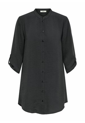 Melns krekls ar pogām, izgatavots no teksturēta auduma, ar garām piedurknēm, kas sarullētas pie acu, stāvīgu apkakli un izliekumu apakšmalā.