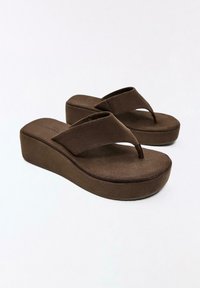Brown platform wedge flip-flop sandals with wide fabric straps and textured sole, displayed on a white background.