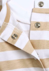 Bomulds polo skjorte krave med skiftende hvide og lysebeige striber, der har sølv trykknapper og et struktureret stof.