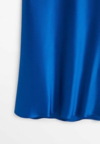 Satiininen sininen kangas, jossa on sileä pinta, pyöreä helma ja pehmeä kiilto. Laskeutuu tyylikkäästi korostaen sen eloisaa väriä.