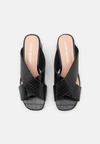 Sandales noires en faux crocodile à enfiler avec des brides croisées. Semelle intérieure lisse, design à bout ouvert, branding discret sur le pied.