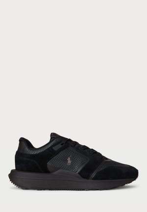 Schwarze Sneakers aus Wildleder und Mesh, mit gepolstertem Kragen, strukturierten Akzenten und einer Gummisohle mit kleinen Nieten für besseren Halt.