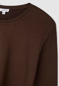 Brązowa bluzka z długim rękawem, okrągły dekolt, miękka tekstura, widoczna metka w rozmiarze 2XL, materiał wydaje się gładki, bez wzorów czy akcentów.