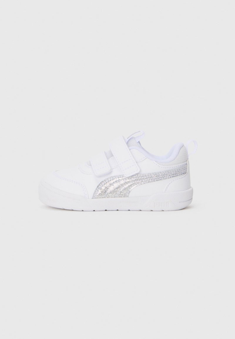 Chaussure de sport blanche avec deux sangles auto-agrippantes, dessus en tissu lisse et accents en paillettes argentées sur le côté. Bout arrondi et semelle légère.