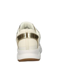 Sneaker bianco con tomaia liscia e un accento dorato lucido sul tallone. Presenta una suola in gomma bianca spessa e dettagli di texture sottili.