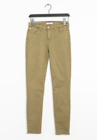 Jeans verde oliva con ajuste slim, hechos de un suave material de algodón. Cuentan con cinco bolsillos, remaches metálicos y un cierre de botón en la parte frontal.