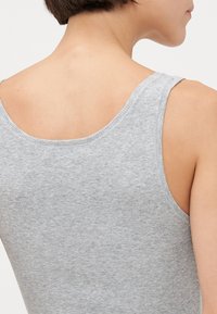 Graues, geripptes Tanktop mit breiten Tragriemen und runder Rückenb neckline, aus weichem, elastischem Stoff hergestellt. Dezente Textur mit minimaler Detailierung.