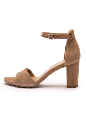 Brązowy sandał na obcasie zamszowy z odkrytymi palcami i regulowanym paskiem wokół kostki z srebrną klamrą, pokazany z boku na białym tle.