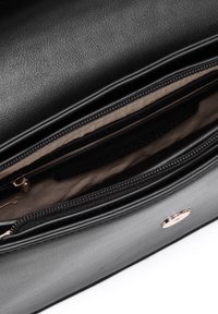 Borsa a tracolla in pelle nera con apertura con cerniera, fodera beige, molteplici scomparti e logo in oro. Finitura liscia e design elegante.