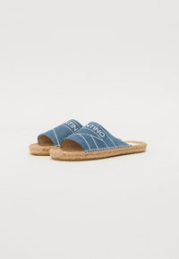 Denim espadrilky s otvorenými prstami, s modrou textíliou, bielym prešívaním a pletenými jute podrážkami. Neformálny dizajn s minimálnymi akcentmi.