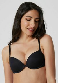 Reggiseno imbottito nero con coppe lisce, spalline regolabili e design senza cuciture. Tessuto morbido e forma arrotondata per una vestibilità di supporto.
