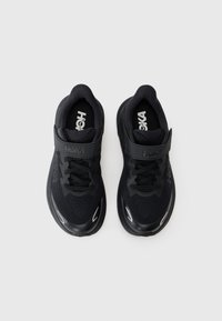 Chaussures de sport noires avec une tige en maille, semelle rembourrée, sangle réglable en velcro et accents réfléchissants, conçues pour le confort et le soutien.