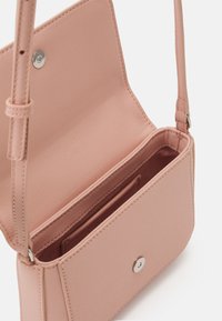 Borsa a tracolla sintetica rosa con superficie testurizzata, chiusura a scatto argentata e scomparti per carte interni. Design compatto e rettangolare.