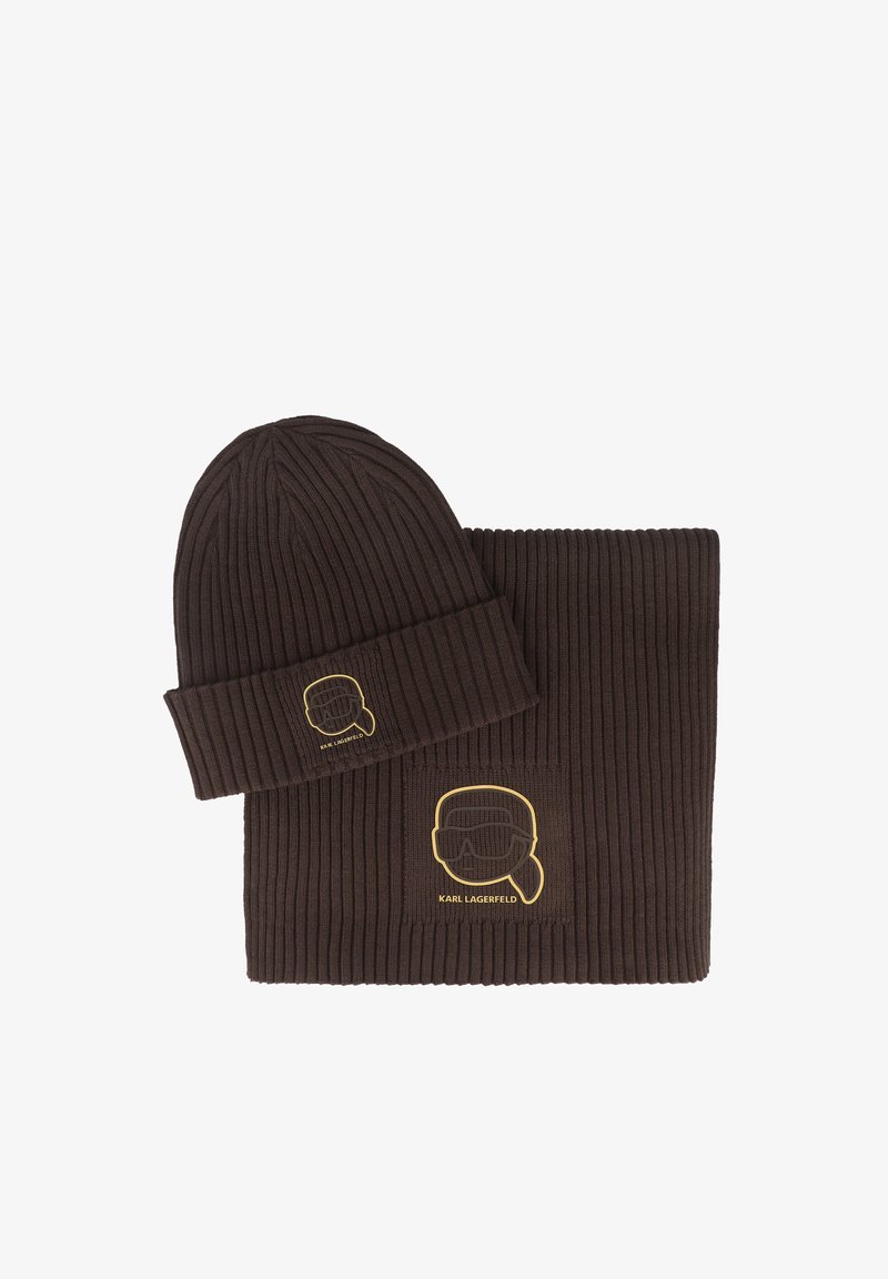 Ensemble bonnet et écharpe en tricot côtelé marron avec un contour jaune représentant un visage. Le bonnet a un revers plié, tandis que l'écharpe est rectangulaire et texturée.