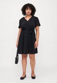 Black dress with short, lace-trimmed sleeves, button-up front, and a tied waist. Smooth fabric with a knee-length fit and minimal design.