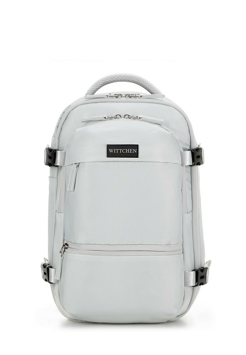Sac à dos gris clair avec plusieurs compartiments, fermetures éclair et bretelles ajustables. Doté d'une poignée supérieure texturée et d'un patch de logo de marque.