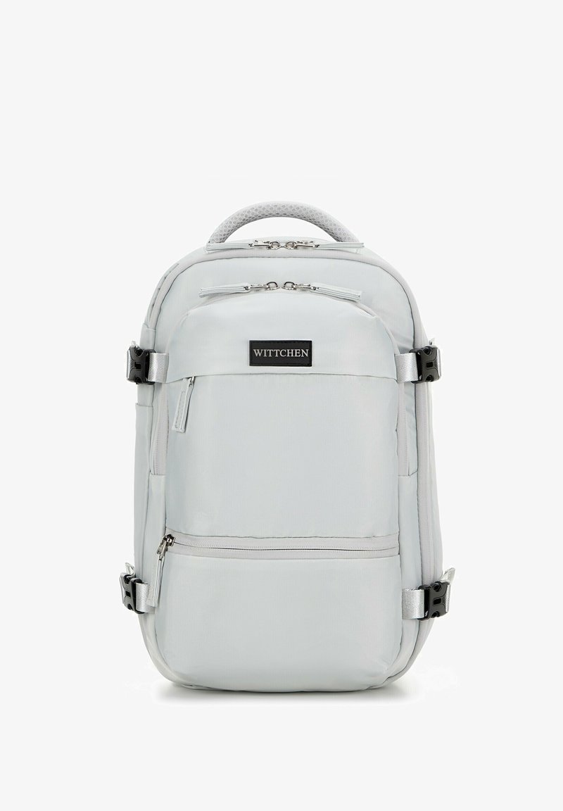 Sac à dos gris clair avec plusieurs compartiments, fermetures éclair et bretelles ajustables. Doté d'une poignée supérieure texturée et d'un patch de logo de marque.