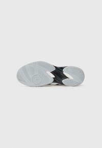 Semelle de chaussure de sport noire avec des motifs texturés, présentant des accents en caoutchouc blanc et un tirant pour l'adhérence. Des contours lisses améliorent la performance.