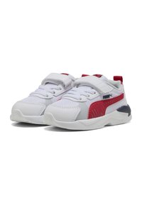 Baskets en mesh blanches avec des accents rouges et navy, dotées d'une sangle Velcro, d'un bout arrondi, d'un col rembourré et d'une semelle texturée pour une meilleure adhérence.