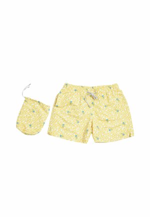 Costume da bagno giallo con motivi di meduse bianche e blu e sacchetto con coulisse abbinato su sfondo bianco.