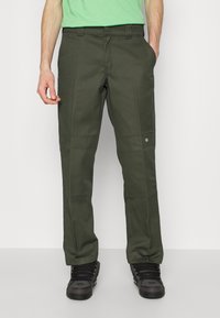 Mörkgröna cargobyxor med rak passform, tillverkade av kraftigt tyg. Har sidfickor och en liten logotypapplikation nära vänster ficka.