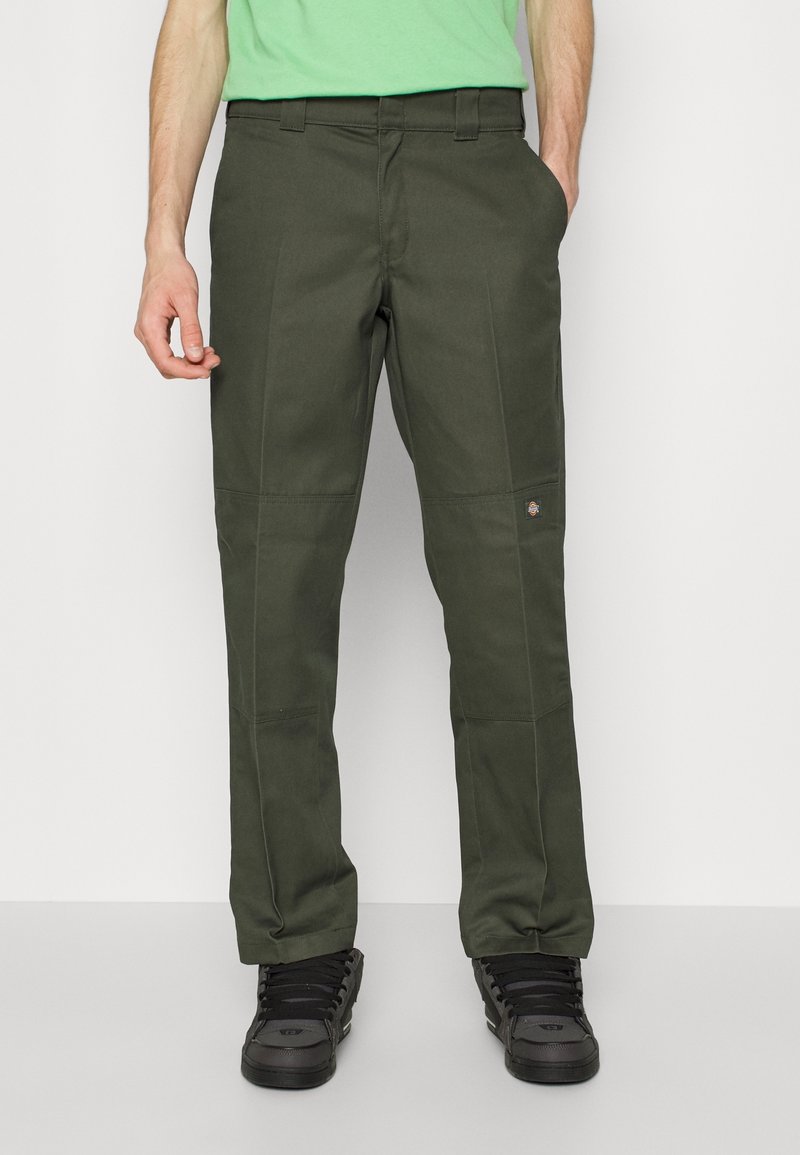 Mörkgröna cargobyxor med rak passform, tillverkade av kraftigt tyg. Har sidfickor och en liten logotypapplikation nära vänster ficka.