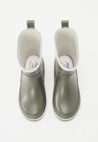 Bottes de pluie en caoutchouc vert avec doublure textile blanche, forme arrondie et bande de tirage. Texture lisse avec une bande de semelle extérieure blanche.