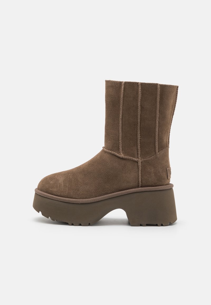 Botte mi-mollet en daim marron avec talon plateforme épais et semelle extérieure rainurée, présentant des coutures verticales visibles et un style enfiler.