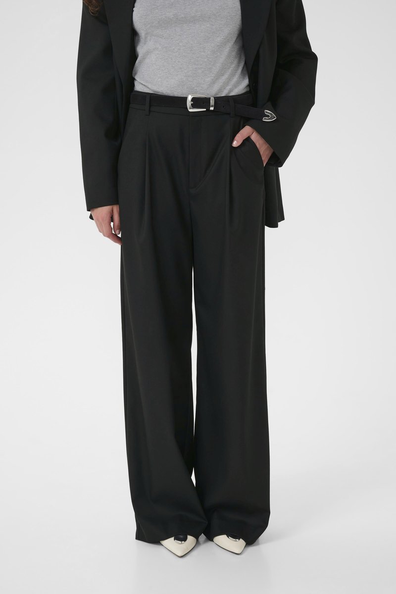 Wide-leg black trousers made from a smooth fabric, featuring front pleats, a waistband with belt loops, and side pockets.