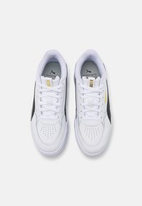 Vita lädersneakers med svarta accenter, rund tå, snördesign, perforerade detaljer på tåboxen och guldlogotyp på tungan.