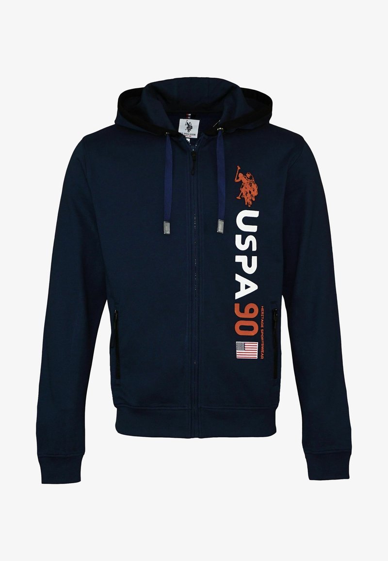Sweat à capuche zippé bleu marine avec capuche et cordons, avec le texte "USPA 90", un logo de joueur de polo et un drapeau américain sur la partie avant droite.