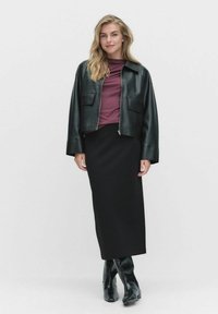 Czarna skórzana kurtka o kroju cropped z dwiema przednimi kieszeniami, bordowy long-sleeve top oraz czarna spódnica do kolan. Całość dopełniają czarne botki na kostkę.