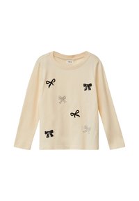 Jasnobeżowa koszula z długim rękawem z aplikacjami kokardek z czarnych i srebrnych cekinów. Posiada okrągły dekolt i miękki bawełniany materiał.