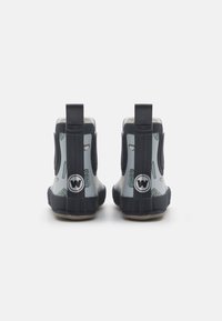 Bottines en caoutchouc bleues avec un design à motifs, dotées d'un panneau latéral élastique noir et d'une languette pour un enfilage facile. Logo embossé visible.