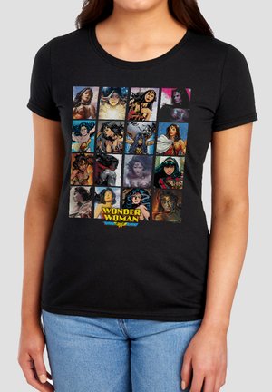 Woman wearing black t-shirt featuring 16 colorful Wonder Woman illustrations in a 4x4 grid with the Wonder Woman logo centered below.