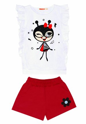 Weißes Rüschenshirt mit Grafik eines Charakters in Schwarz und Rot; rote Shorts mit elastischem Bund und einer schwarzen Blumenapplikation.