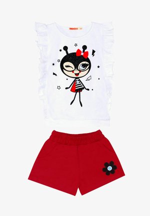 Haut blanc froncé avec un graphique de personnage noir et rouge ; short rouge avec une taille élastique et une appliqué de fleur noire.