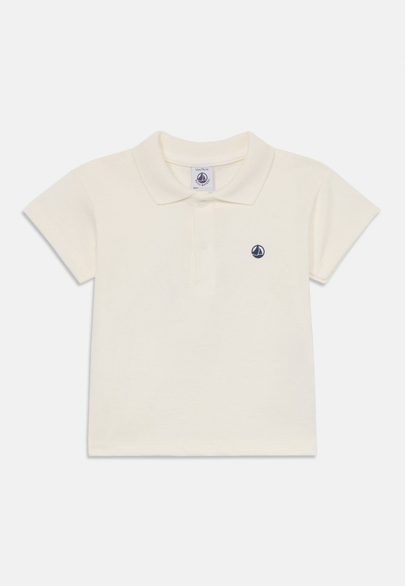 Pehmeast kreemjast puuvillast polo-särk klassikalise kraega ja lühikeste varrukatega. Vasal on vasakul rinnal väike tumesinine purjekas-logo.