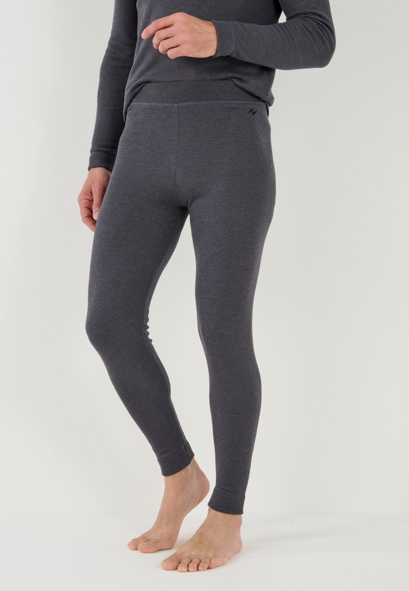 Leggings grises hechos de un material suave y elástico. Tienen una cintura alta y un diseño ajustado que se estrecha en el tobillo. Sin patrones visibles.