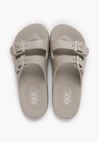 Beige plastik sandaler med to justerbare stropper med firkantede spænder. Struktureret fodsenge og branding på sålen. Blødt, fleksibelt materiale.