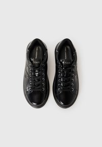 Pair of black leather Karl Lagerfeld sneakers with black laces, viewed from above on a white background.