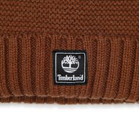 Berretto lavorato a maglia marrone con risvolto a coste e un'etichetta del logo Timberland nera con una grafica ad albero. Il materiale sembra morbido e strutturato.