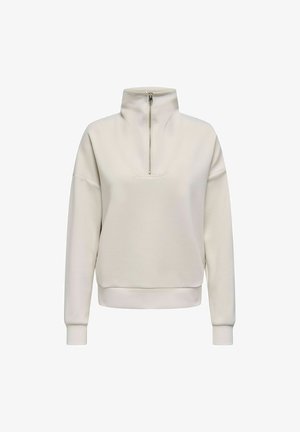 Light beige pullover with a half-zip collar, soft fabric, relaxed fit, ribbed cuffs, and a distinct V-shaped seam on the front.