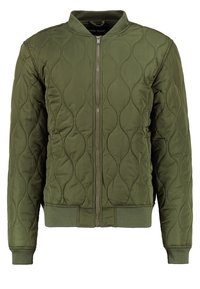 Kurtka typu bomber w oliwkowo-zielonym kolorze z pikowanym wzorem, z zamkiem błyskawicznym, ściągaczami na rękawach i u dołu. Wykonana z gładkiego syntetycznego materiału.