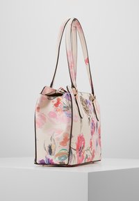 Blommig totebag med en krämfärgad bakgrund, prydd med rosa och lila blommor, kontrasterande bruna kanter och dubbla axelremmar. Guld detaljer.