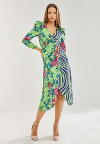 Floral and zebra print dress featuring long sleeves, a deep v-neck, ruched shoulders, and a wrap design in green, pink, and purple hues.