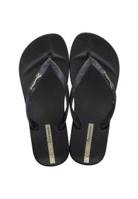 Black flip-flops with textured soles and narrow straps. Features a metallic gold accent with branding and a smooth, flat design.